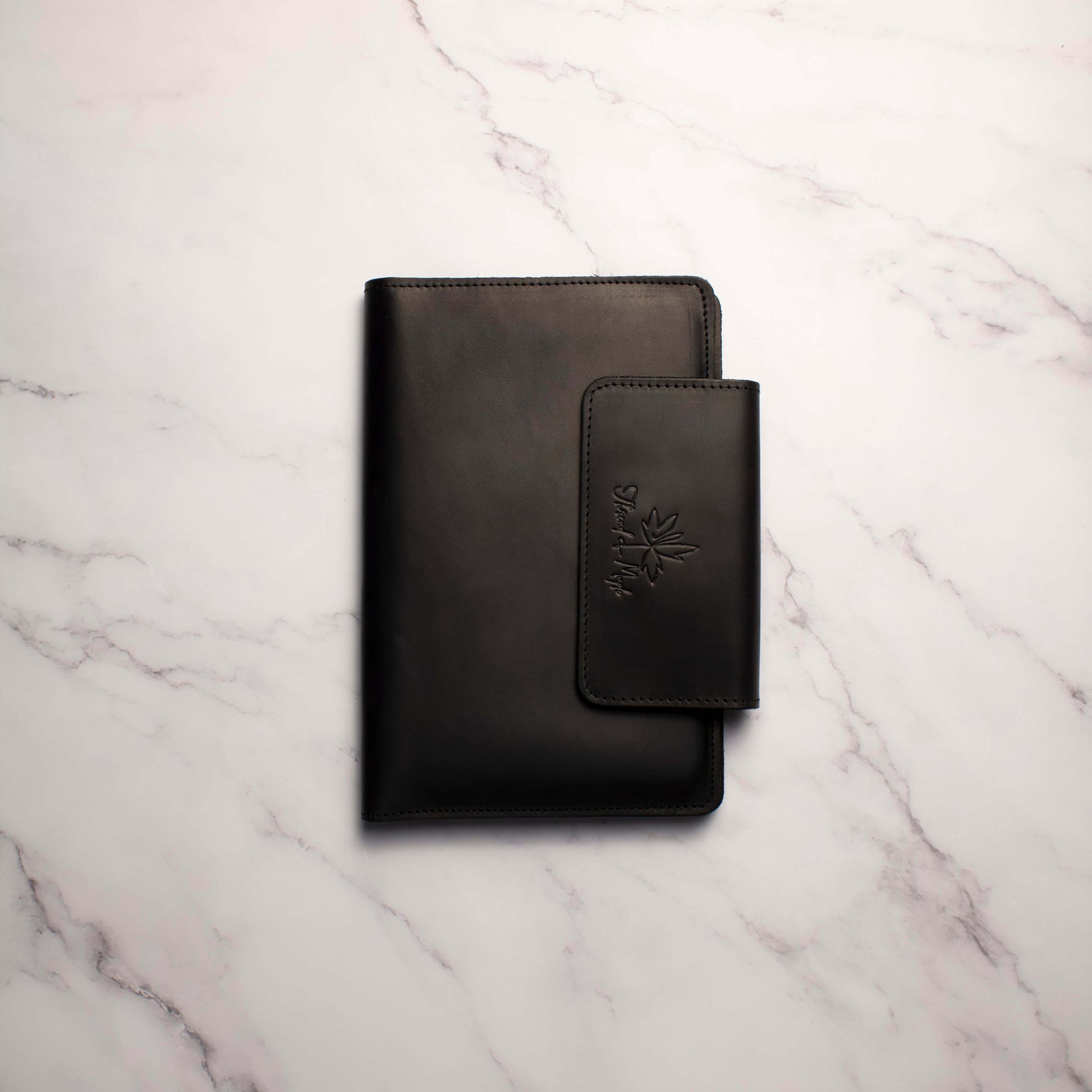 Black leather wallet on a marble surface.