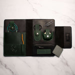 leather tech organizer with cables, earbuds, and accessories on marble surface