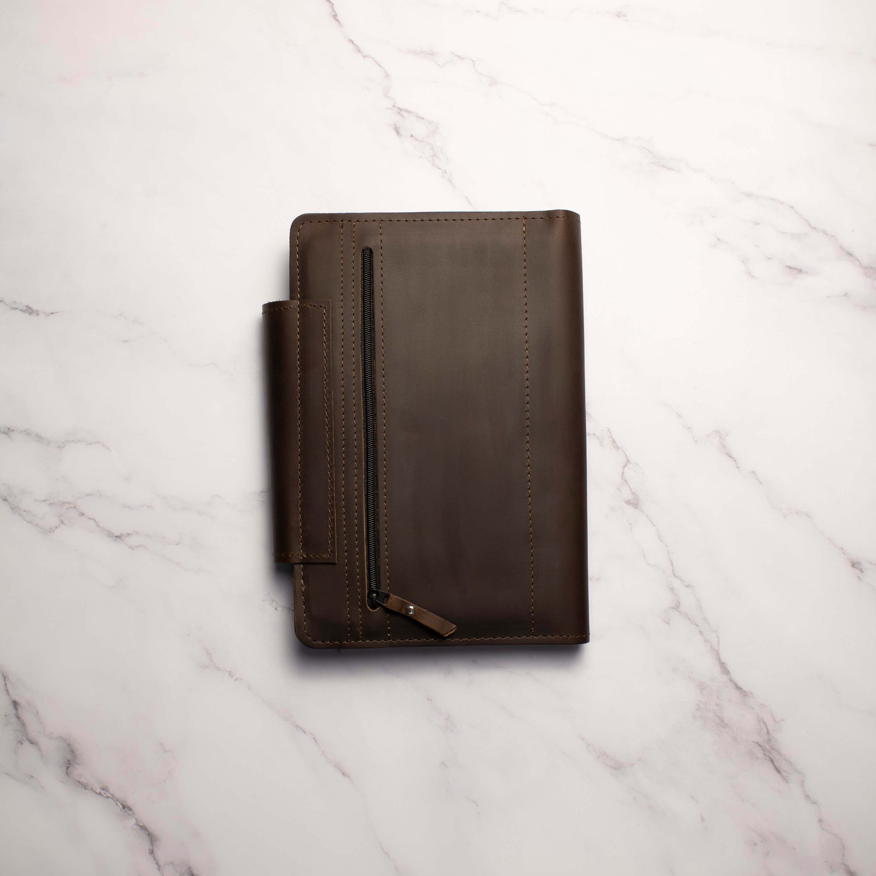 Brown leather portfolio organizer on a marble surface