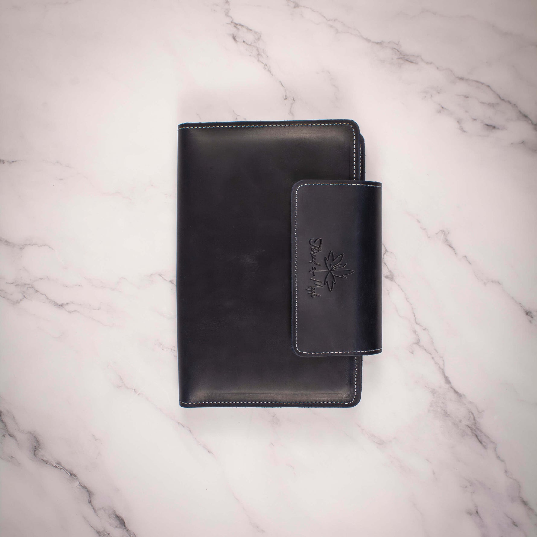 Black leather wallet on a marble surface.