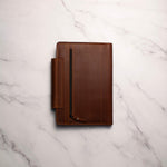 Brown leather notebook on a white marble surface